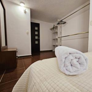 a bedroom with a bed with a towel on it at Isabella's Cottage in Cholula