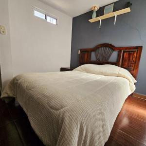 a bedroom with a large bed with a wooden headboard at Isabella's Cottage in Cholula +6 photos