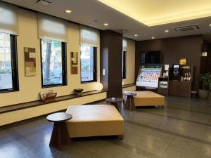 a lobby with benches and windows in a building at Hotel Route-Inn Nagoya Imaike Ekimae in Nagoya +23 photos