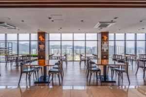 a restaurant with tables and chairs and large windows at Chestertons Gyeongju in Gyeongju