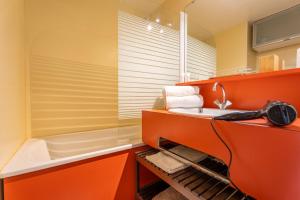an orange bathroom with a sink and a tub at Mountain View with Ski-In and Out Loft - Résidence Roche Blanche in Val Thorens