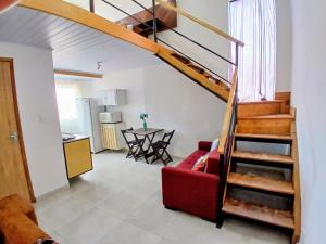 a living room with a staircase and a red couch at Conforto e Praticidade, Studio para 2 pessoas in Ponta Grossa