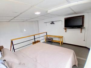 a bedroom with a bed and a flat screen tv at Conforto e Praticidade, Studio para 2 pessoas in Ponta Grossa +6 photos
