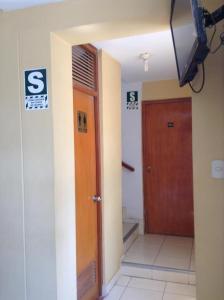 a hallway of a building with a door and a television at Hostal La Estancia in Ica