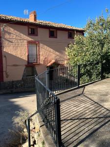 a fence in front of a house with a building at La Casonna - Aluenda in El Frasno +41 photos