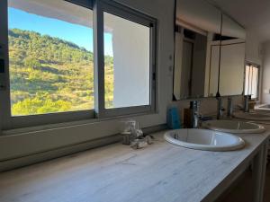 a bathroom with two sinks and a large window at La Casonna - Aluenda in El Frasno