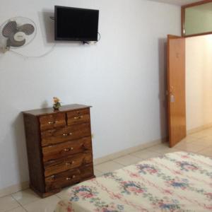 1 dormitorio con tocador y TV en la pared en Hostal La Estancia, en Ica