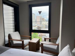 a hotel room with two chairs and a window at hotel bolam kyoto in Shimo-dachiyuuridōri