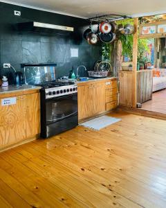 a kitchen with a stove and a wooden floor at Yagan house in Puerto Natales +42 photos