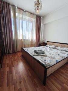 a bedroom with a bed with a phone on it at Xata 1+2 in Almaty