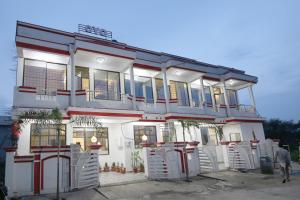a white building with chairs in front of it at Hotel O Atithi Home Stay in Garhā
