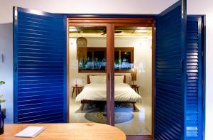 a bedroom with blue walls and a bed in a room at Confluence Siargao in General Luna