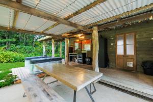 a patio with a wooden table and a kitchen at Cascade Springs in North Tumbulgum +5 photos