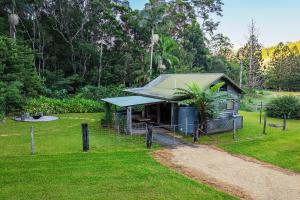 a small house with a fence in a yard at Cascade Springs in North Tumbulgum