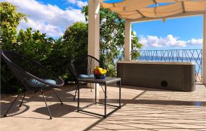 a patio with two chairs and a table with a bowl of fruit at Holiday Home Grljevacka Vi in Podstrana +42 photos