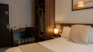 a hotel room with a bed and a desk at The Watling Inn in Nuneaton