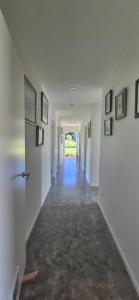 a hallway with white walls and pictures on the walls at Ginrosa B and B accommodation in Featherston