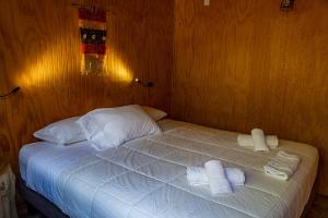 a bedroom with a bed with two towels on it at Cabañas Origen Bosque y Río in Melipeuco