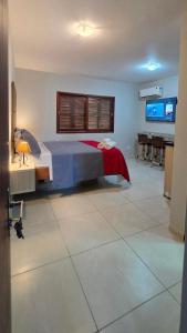 a bedroom with a bed and a desk and a television at Flats Marina do Sol in Florianópolis