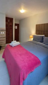a bedroom with a large bed with a pink blanket at Flats Marina do Sol in Florianópolis