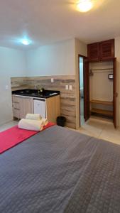 a bedroom with a large bed and a kitchen at Flats Marina do Sol in Florianópolis +30 photos