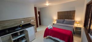 a bedroom with a large bed with a red blanket at Flats Marina do Sol in Florianópolis