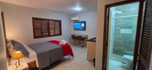 a bedroom with a bed and a bathroom at Flats Marina do Sol in Florianópolis