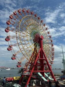 a large ferris wheel on a pier next to the water at Private Inn Bambee in Kobe