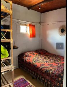 a small bedroom with a bed and a ladder at Casa Sur in Cabo Polonio