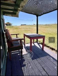 a table and a chair sitting on a porch at Casa Sur in Cabo Polonio