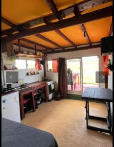 a room with a kitchen with a table and a refrigerator at Casa Sur in Cabo Polonio +2 photos