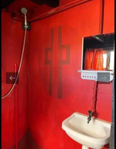 a red bathroom with a toilet and a red wall at Casa Sur in Cabo Polonio