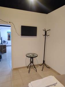 a room with a table and a television on a wall at Alojamiento El Centenario in San Martín