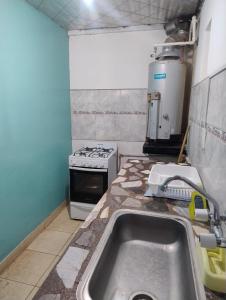 a kitchen with a sink and a stove at Alojamiento El Centenario in San Martín +3 photos