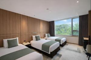 a hotel room with two beds and a window at Golden Seoul Hotel in Seoul