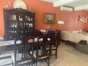 a dining room with a table and chairs and a couch at Casa Palma in Santa Cruz Huatulco