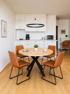 a kitchen with a table and chairs in a room at Ferienwohnung -West Häfele Blick in Hagnau