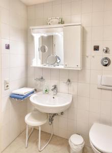 a white bathroom with a sink and a toilet at Ferienwohnung -West Häfele Blick in Hagnau