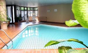 a large swimming pool in a large room with at Ferienwohnung -West Häfele Blick in Hagnau