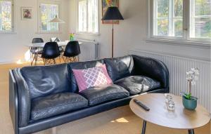 a black leather couch in a living room with a table at Nice Home In Ry With Wifi in Ry