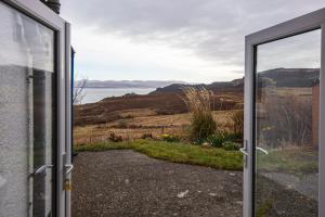 an open door to a view of the water at Ard Dhub House Your 3 Bedroom cottage retreat in Waternish in Hallin