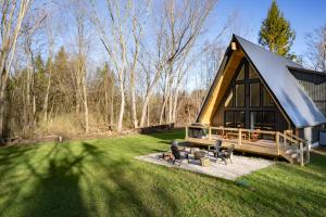 a log cabin with a fire pit in the yard at Secluded Architectural A-Frame w/ Soaring Windows & Fire Pit in South Haven