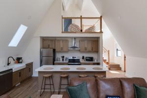 a kitchen with a couch and a table in a room at Secluded Architectural A-Frame w/ Soaring Windows & Fire Pit in South Haven