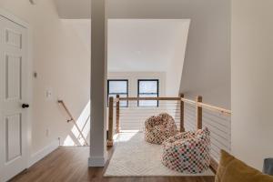 a staircase with two chairs in a house at Secluded Architectural A-Frame w/ Soaring Windows & Fire Pit in South Haven