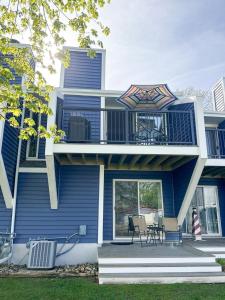 a blue house with a balcony with two chairs at Newly Renovated Condo in Harborside! in South Haven