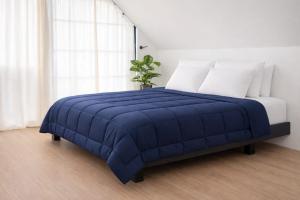 a blue bed with white pillows and a blue blanket at Margaritas House in Buenos Aires