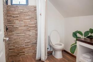 a bathroom with a toilet and a brick wall at Margaritas House in Buenos Aires