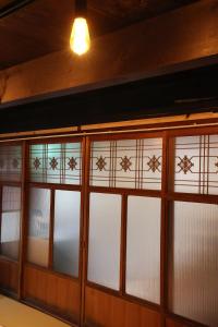 a row of glass doors with a light on top at 古民家宿そらいえ in Asago