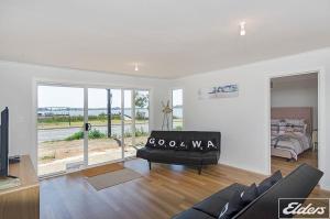 a living room with a couch and a bed at Riverside Dream - 109 Barrage Rd in Goolwa South +13 photos