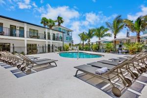 a resort with lounge chairs and a swimming pool at Tropic Isle At Anna Maria Island Inn in Bradenton Beach